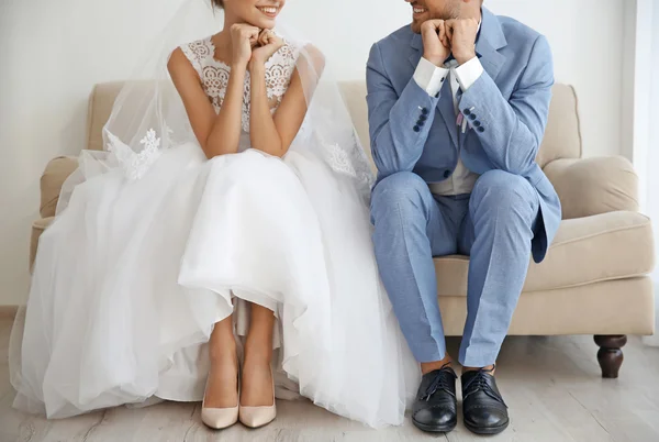 Groom and bride sitting on couch — Stock Photo, Image