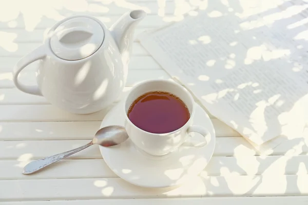 Taza de té con sombras sobre mesa de madera — Foto de Stock