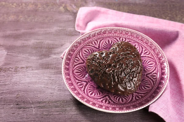 Corazón de chocolate en un plato rosa — Foto de Stock