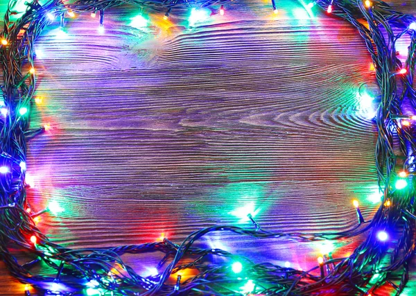 Christmas lights on a wooden background — Stock Photo, Image