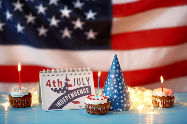 Cupcakes con calendario sobre fondo borroso de la bandera americana. Concepto del día de la independencia —  Fotos de Stock