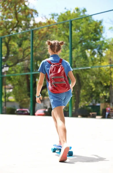 Jong meisje paardrijden skateboard — Stockfoto