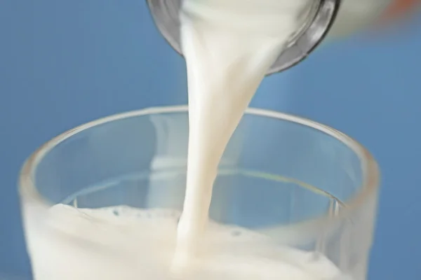 Milk pouring from bottle — Stock Photo, Image