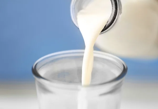 Milk pouring from bottle — Stock Photo, Image
