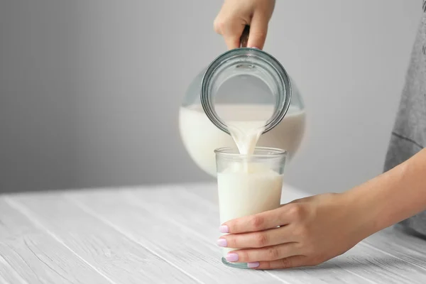 Hand pouring milk — Stock Photo, Image