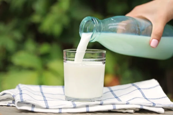 Hand gießt Milch — Stockfoto