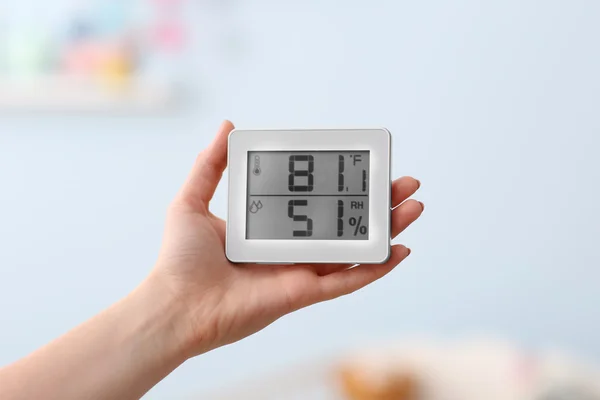 Woman checking temperature and humidity in baby room — Stock Image Woman checking temperature and humidity in baby room Stock Image