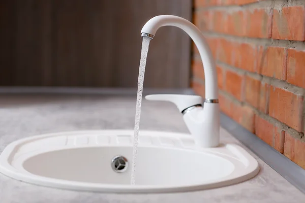 Water flowing from faucet to sink — Stock Photo, Image