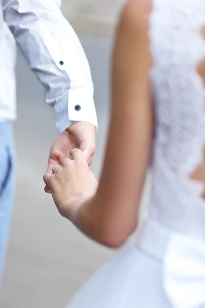 Bride and groom holding hands — Stock Photo, Image