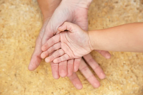 Family hands on stone background