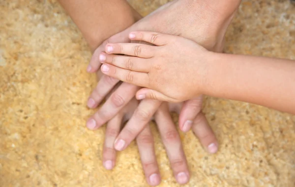 Семейные руки на каменном фоне — стоковое фото