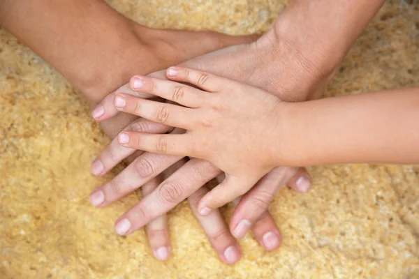 Familie handen op stenen achtergrond — Stockfoto