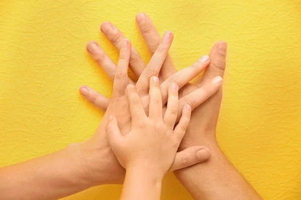 Family hands on yellow background — Stock Photo, Image