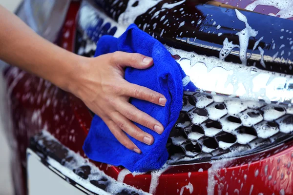 Serviceman washing a car