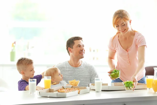 幸せな家族は台所でピザを食べる — ストック写真