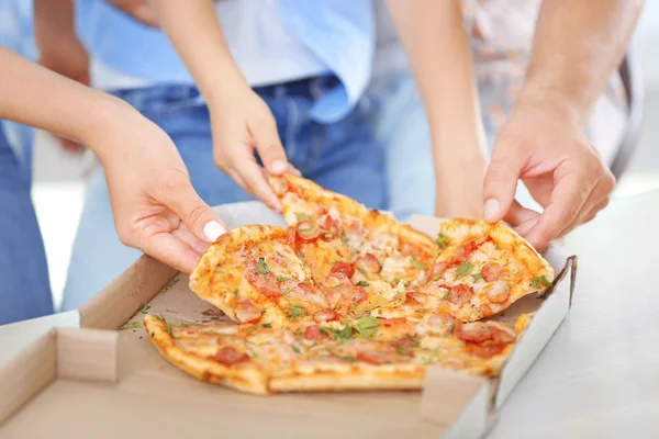 Mãos tirando pizza da mesa, close-up — Fotografia de Stock