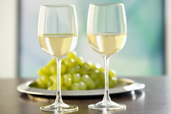 Glasses with white wine and grape on a table — Stock Photo, Image