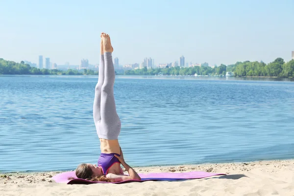 Vrouw doet yoga door rivier — Stockfoto