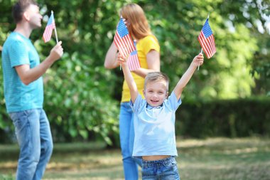 Park Amerikan bayrakları ile mutlu aile