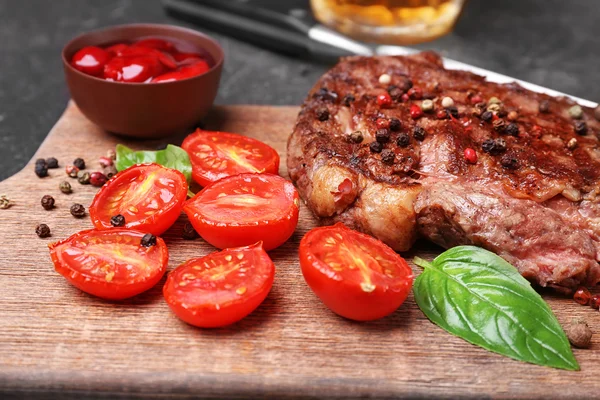 Välsmakande biff med tomat och kryddor på skärbräda — Stockfoto