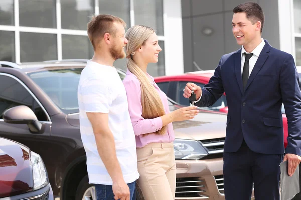 Pareja Joven Comprando Coche Centro Concesionarios —  Fotos de Stock