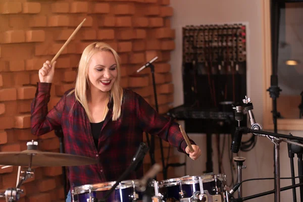 Woman playing drums in a recording studio