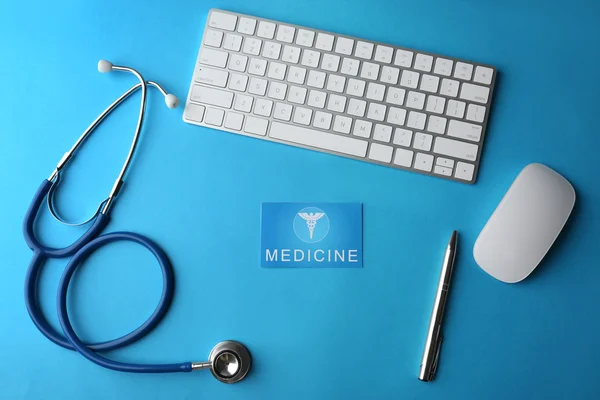 Stetoscopio con tastiera e mouse su sfondo blu — Foto Stock