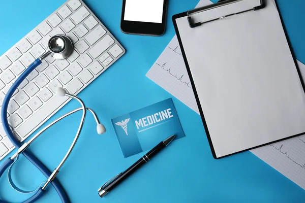 Stethoskop mit Tastatur, Karte und Klemmbrett auf blauem Hintergrund — Stockfoto