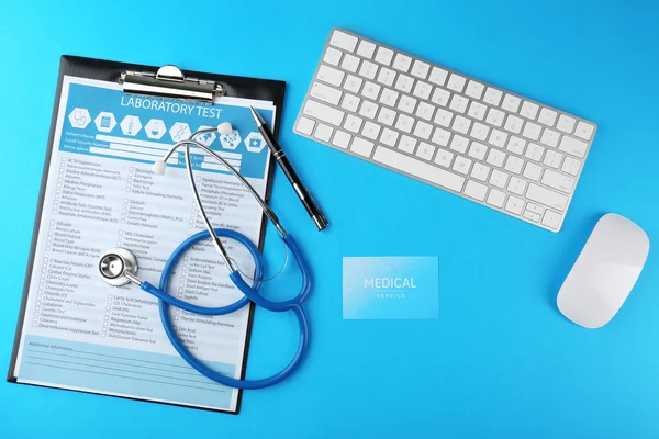 Stethoscoop met toetsenbord, muis en Klembord op blauwe achtergrond — Stockfoto