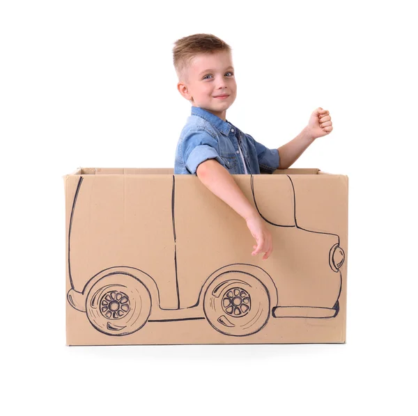 Creative boy playing with cardboard car — Stock Photo, Image