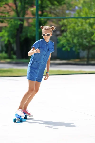 Jong meisje paardrijden skateboard — Stockfoto