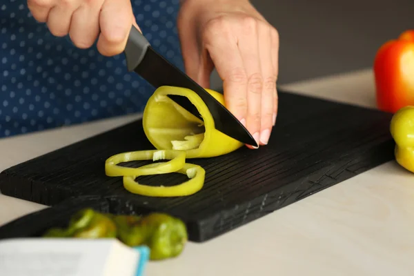 Mujer preparando pimientos en la cocina — Foto de Stock