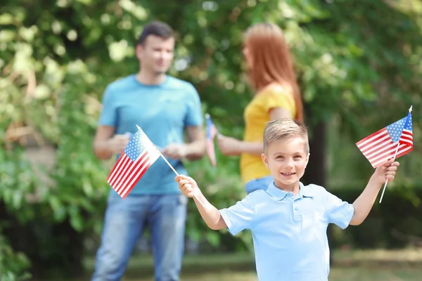 Happy family with American flags in park — Stock Photo, Image