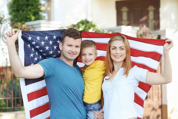 Happy family with American flag in the yard — Stock Photo, Image