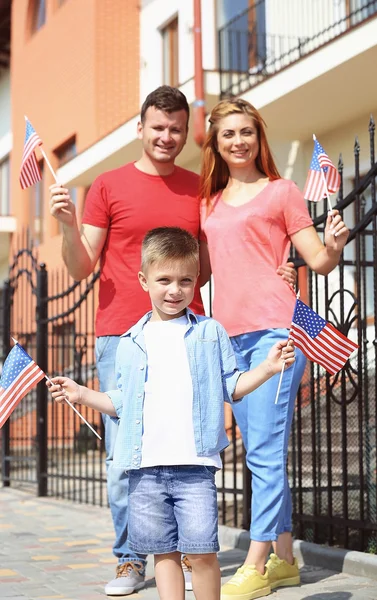 Happy family with American flags in the yard — Stock Photo, Image