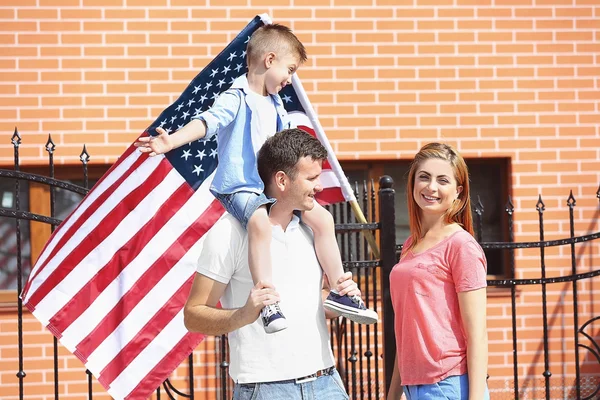 Happy family with American flag in the yard — Stock Photo, Image