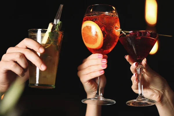 Friends toasting with cocktails in bar