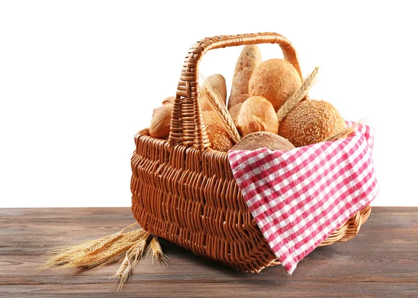 Coș de răchită cu pâine proaspătă pe masă de lemn — Fotografie, imagine de stoc