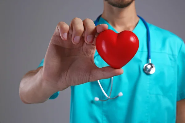 Médico varón sosteniendo el corazón rojo, primer plano —  Fotos de Stock