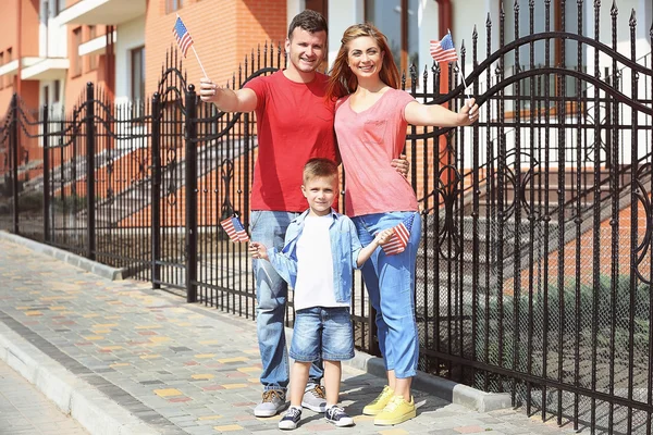 Familia feliz con banderas americanas en el patio Imagen de archivo