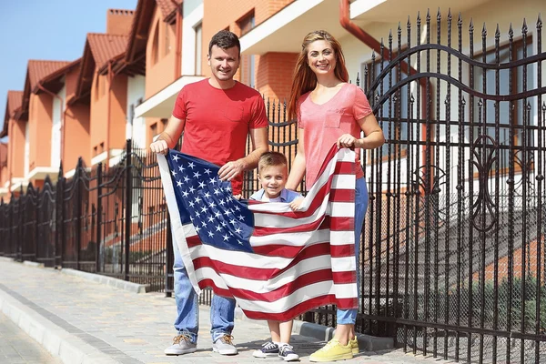 Familia feliz con bandera americana en el patio Imagen de archivo