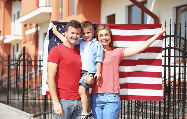 Familia feliz con bandera americana en el patio Imagen de stock