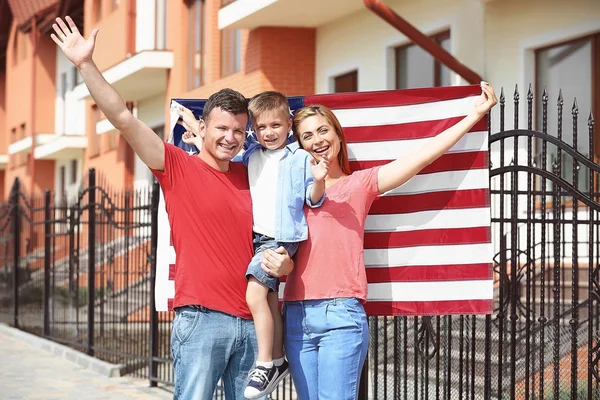 Família feliz com bandeira americana no quintal Imagens Royalty-Free