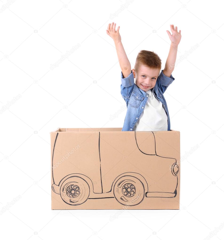 Creative boy playing with cardboard car