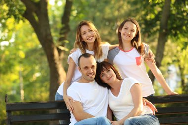 Modern aile parkta bankta oturmuş