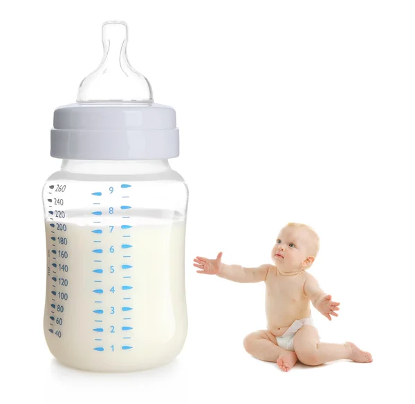 逗人喜爱的婴孩坐在大哺养的瓶附近与牛奶在白色背景 — 图库照片