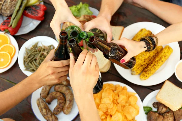 Amigos aplaudindo com garrafas — Fotografia de Stock