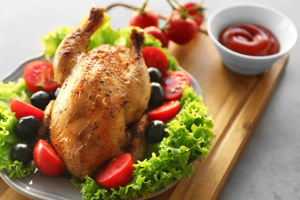 Plate with roasted chicken, olives and tomatoes on wooden cutting board — Stock Photo, Image