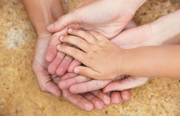 Familia manos sobre fondo de piedra —  Fotos de Stock