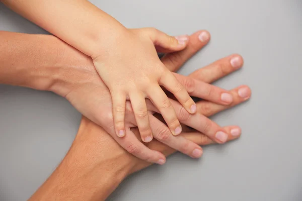 Mani di famiglia su sfondo grigio — Foto Stock